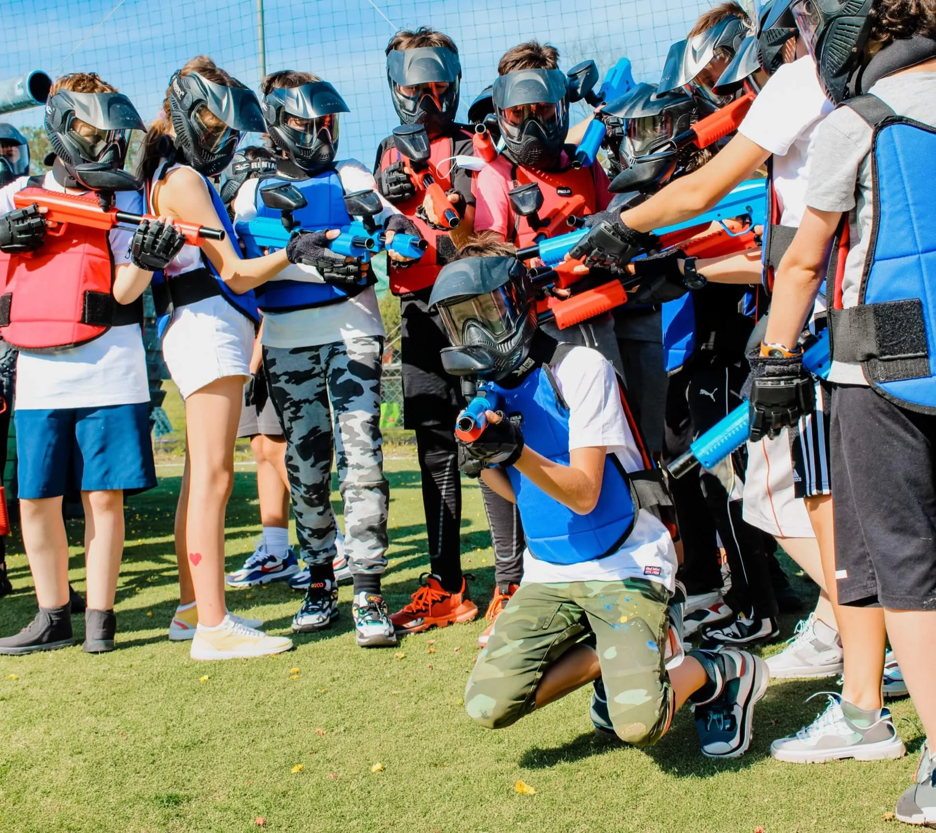 Gruppo di bambini con maschere e tute da paintball pronti a giocare